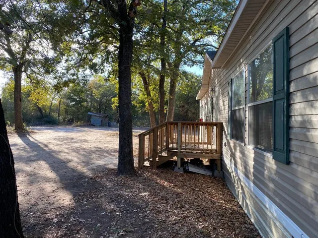 a view of a house with backyard and wooden fence