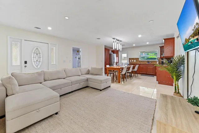 a open kitchen with stainless steel appliances granite countertop a stove a refrigerator a sink dishwasher a dining table and chairs with wooden floor