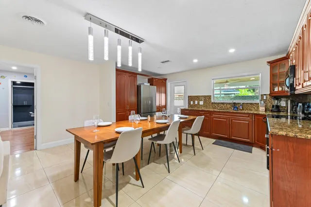 a kitchen with a table chairs microwave and cabinets