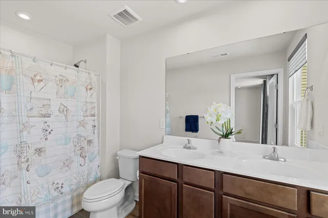 a bathroom with a sink toilet a mirror and shower