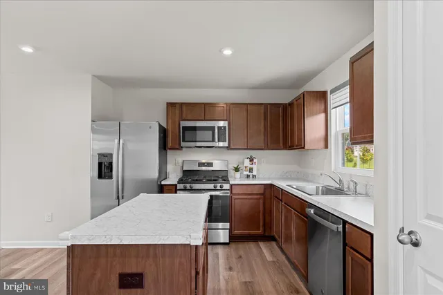 a kitchen with stainless steel appliances granite countertop a sink stove microwave and refrigerator