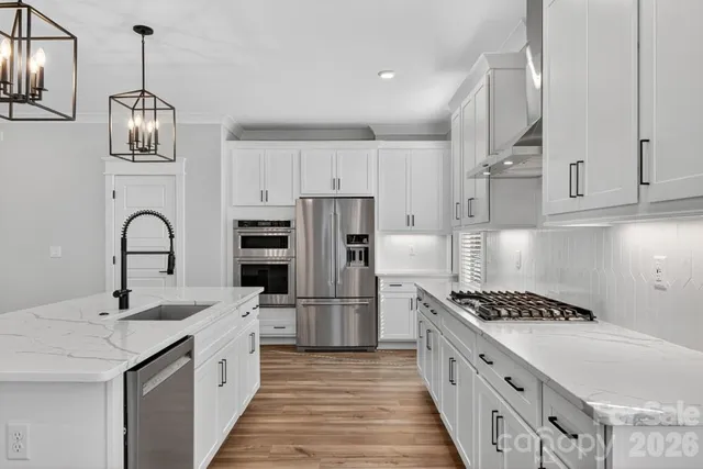 a kitchen with stainless steel appliances kitchen island a white stove top oven and cabinets
