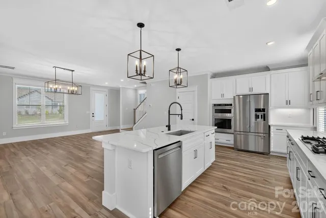 a kitchen with stainless steel appliances granite countertop a sink stove and refrigerator