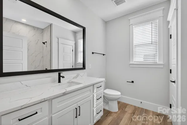 a bathroom with a sink a toilet and a mirror