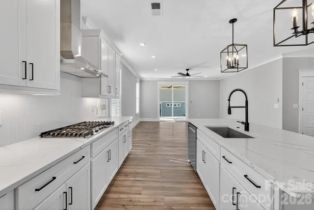 a kitchen with granite countertop a sink stove and cabinets