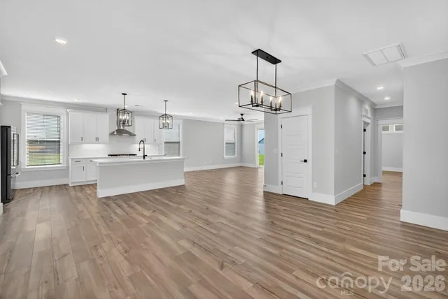 a view of a kitchen with wooden floor and a sink