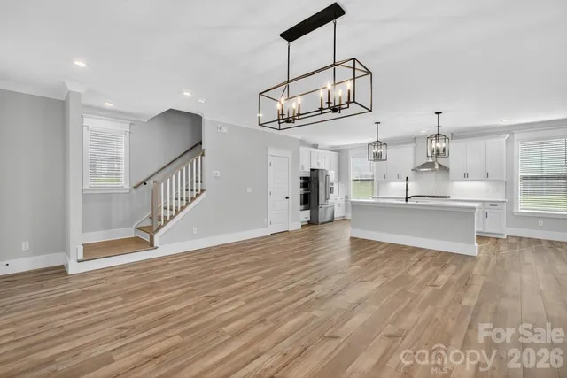 a view of a kitchen with wooden floor and electronic appliances