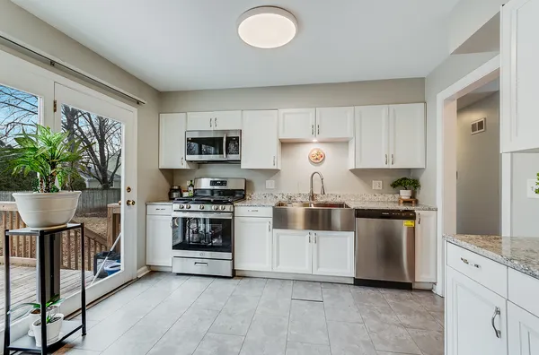 a kitchen with stainless steel appliances granite countertop a stove a sink and a refrigerator