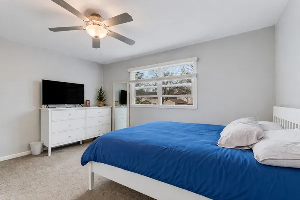 a bedroom with a bed tv and a window