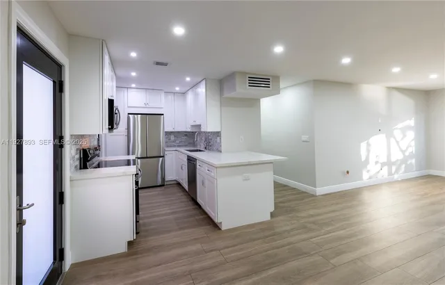 a kitchen with a refrigerator and a stove top oven
