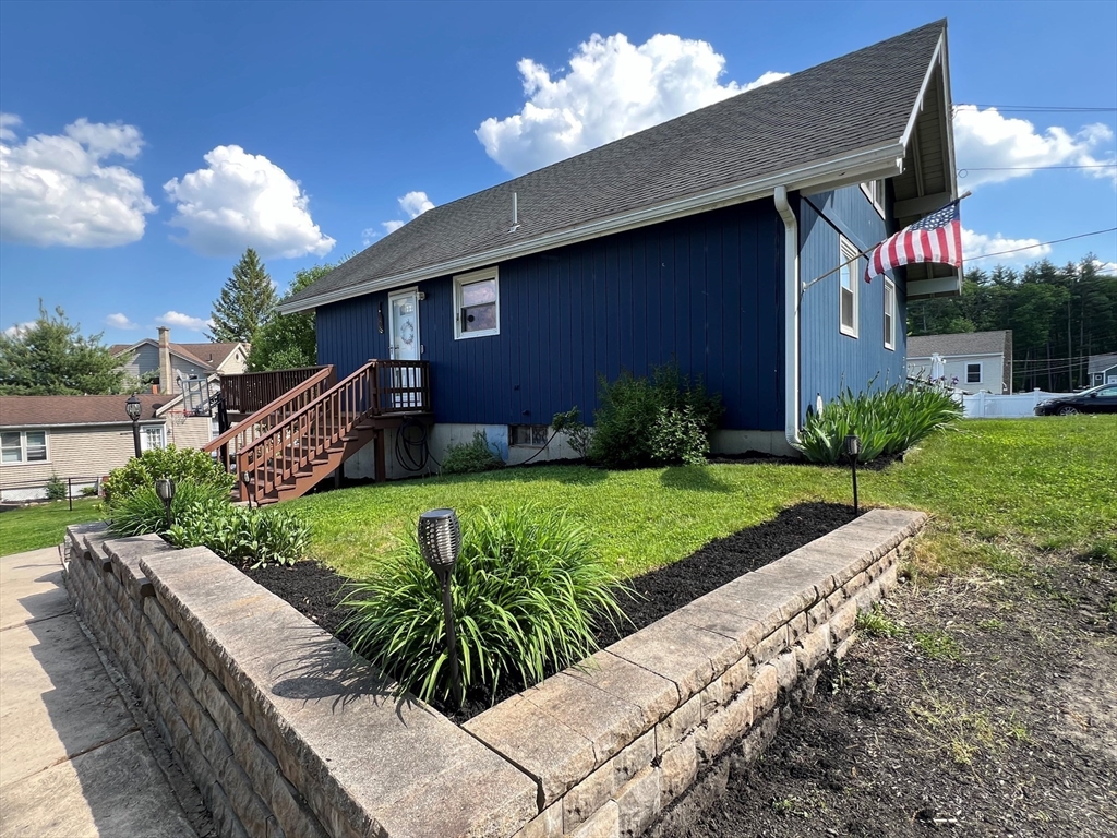 607 Reservoir Road Lunenburg, MA 01462 - Photo 4 of 41 a view of a house with brick walls plants and large tree
