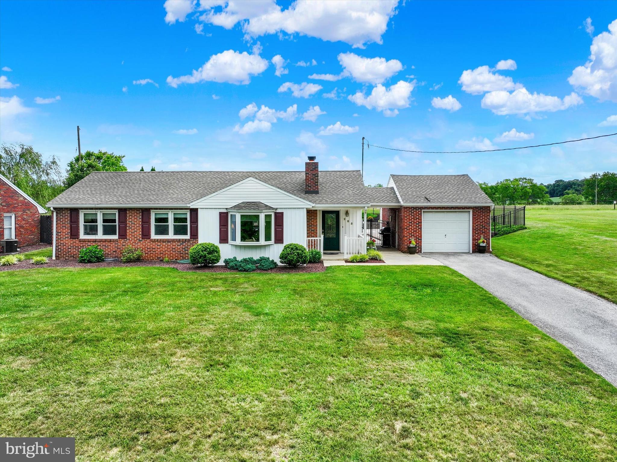 a front view of a house with yard and green space