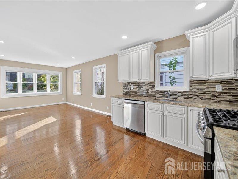 54 Freeman Street Woodbridge, NJ 07095 - Photo 15 of 35 a kitchen with granite countertop white cabinets and wooden floor