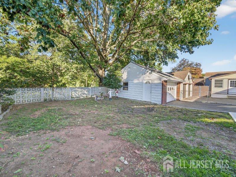 54 Freeman Street Woodbridge, NJ 07095 - Photo 6 of 35 a backyard of a house with large trees and wooden fence