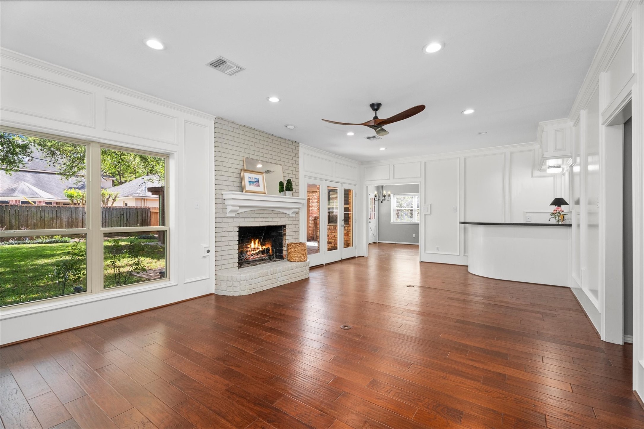 16267 Salmon Lane Spring, TX 77379 - Photo 17 of 48 A traditional wood-burning fireplace is centered in this living room, with warm wood floors continuing throughout and a fun, curved wet bar adds interest.