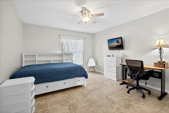 a bedroom with a bed a desk and a chandelier