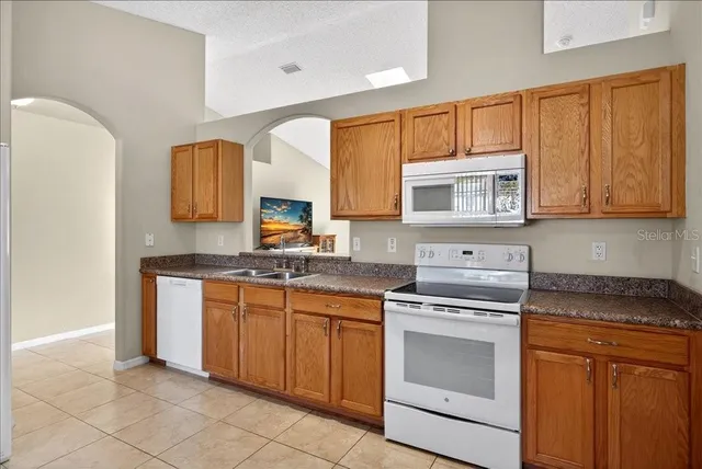 a kitchen with cabinets appliances a sink and a window