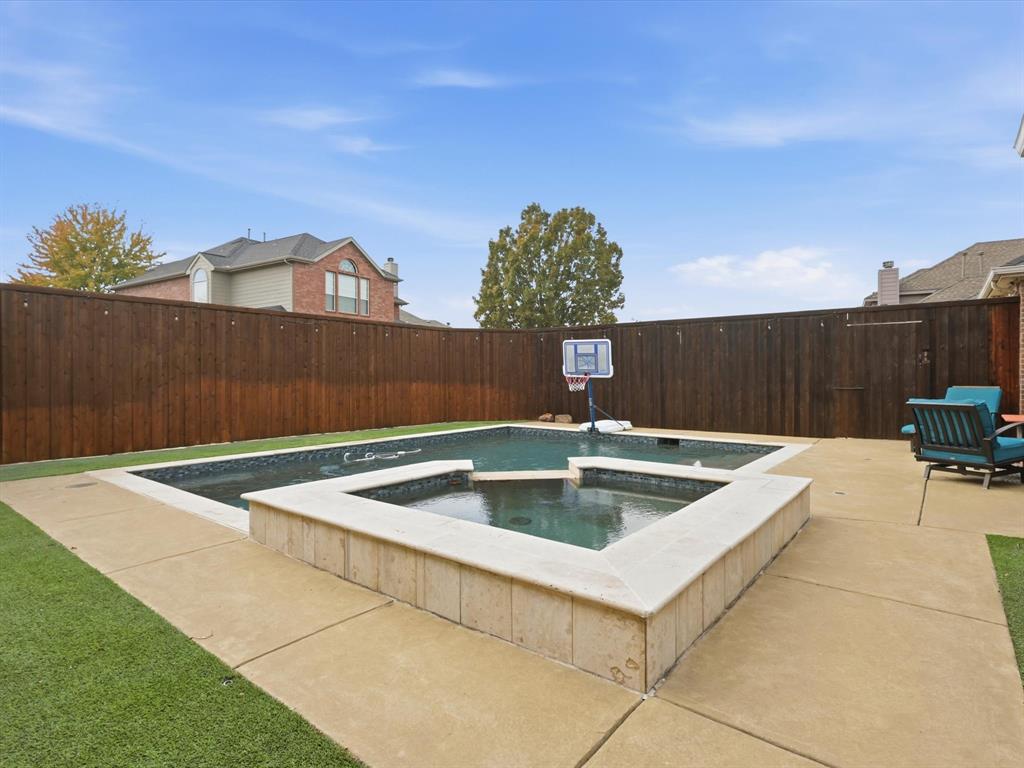 View of pool with a patio, a fenced backyard, and a pool with connected hot tub