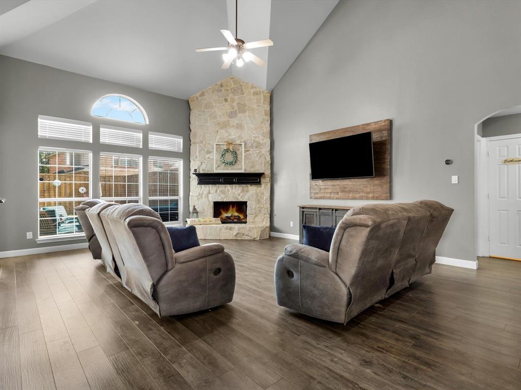 1803 Timber Ridge Drive Frisco, TX 75036 - Photo 13 of 40 Living area featuring high vaulted ceiling, a stone fireplace, a ceiling fan, dark wood finished floors, and arched walkways