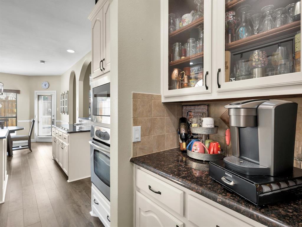 1803 Timber Ridge Drive Frisco, TX 75036 - Photo 16 of 40 Kitchen with white cabinets, glass insert cabinets, appliances with stainless steel finishes, and recessed lighting