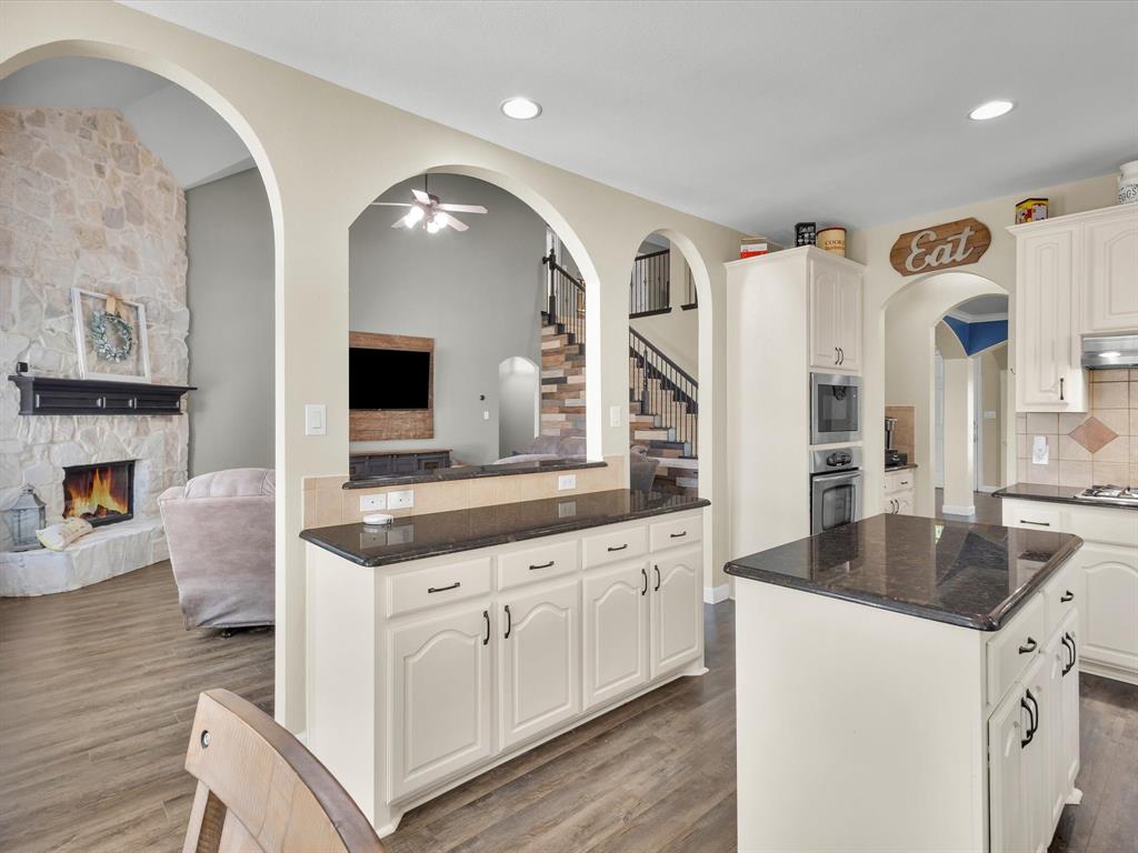 1803 Timber Ridge Drive Frisco, TX 75036 - Photo 40 of 40 Kitchen with open floor plan, dark stone countertops, a kitchen island, dark wood-style floors, and recessed lighting
