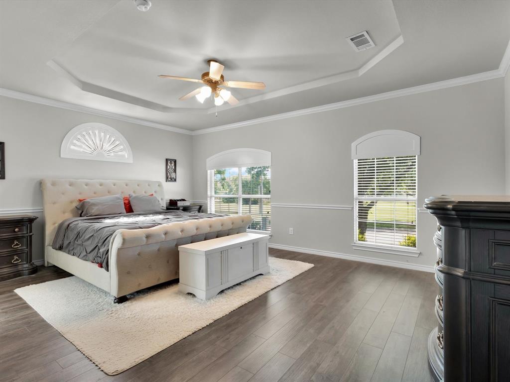 1803 Timber Ridge Drive Frisco, TX 75036 - Photo 20 of 40 Bedroom with a raised ceiling, ornamental molding, ceiling fan, and wood finished floors
