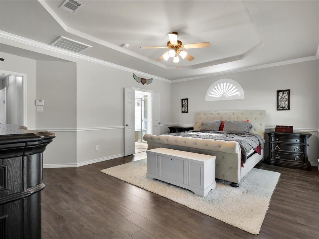 1803 Timber Ridge Drive Frisco, TX 75036 - Photo 21 of 40 Bedroom featuring a tray ceiling, dark wood finished floors, ceiling fan, and ornamental molding