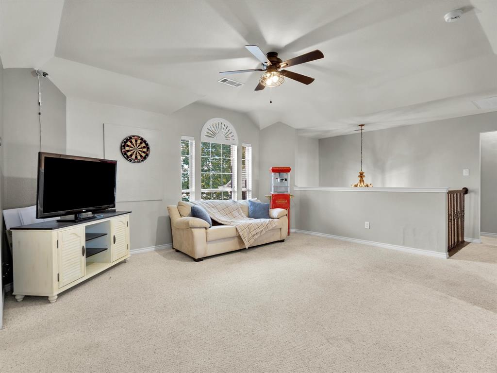 1803 Timber Ridge Drive Frisco, TX 75036 - Photo 25 of 40 Living room with ceiling fan, light carpet, and vaulted ceiling