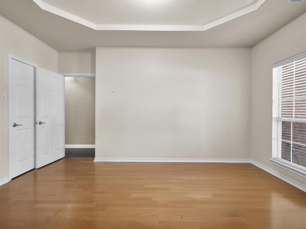 1803 Timber Ridge Drive Frisco, TX 75036 - Photo 5 of 40 Unfurnished bedroom featuring wood finished floors and a raised ceiling