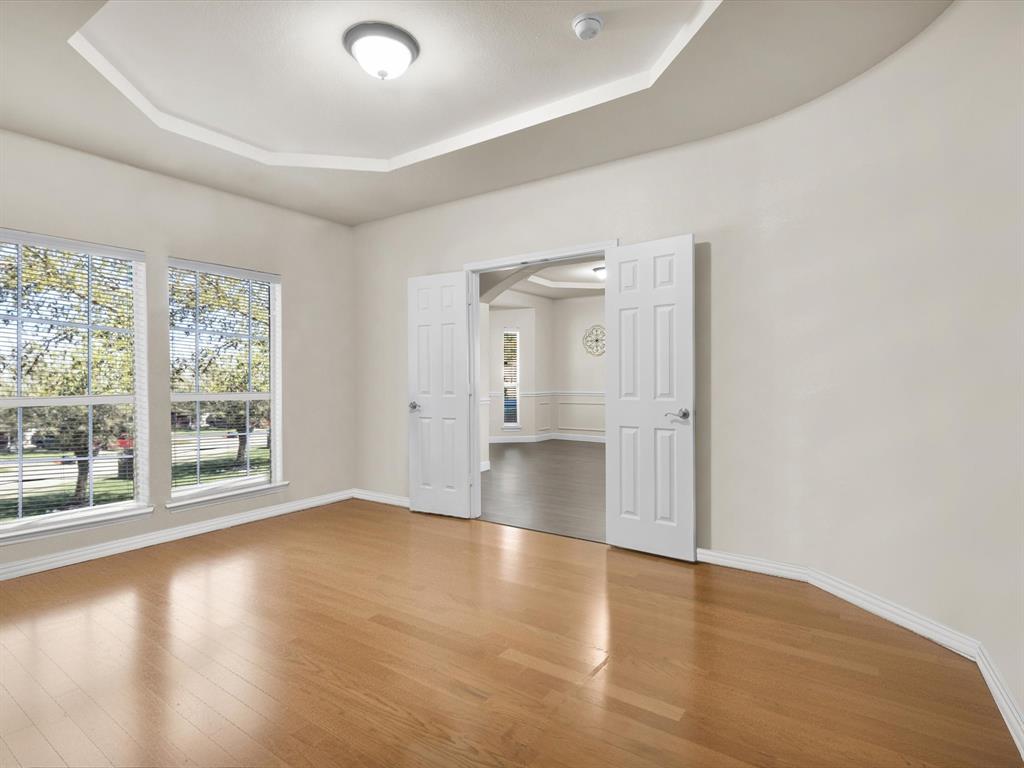 1803 Timber Ridge Drive Frisco, TX 75036 - Photo 7 of 40 Unfurnished room with wood finished floors, arched walkways, and a tray ceiling
