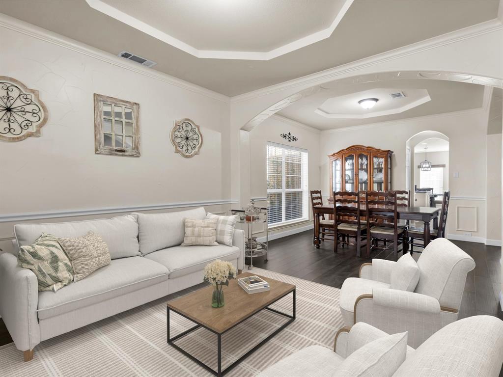1803 Timber Ridge Drive Frisco, TX 75036 - Photo 10 of 40 Virtually staged Living area with a raised ceiling, arched walkways, hardwood / wood-style floors, wainscoting, and a decorative wall