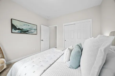 a bedroom with a bed and a painting on the wall