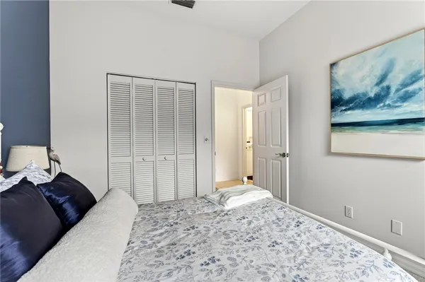 a bedroom with a bed and a painting on the wall