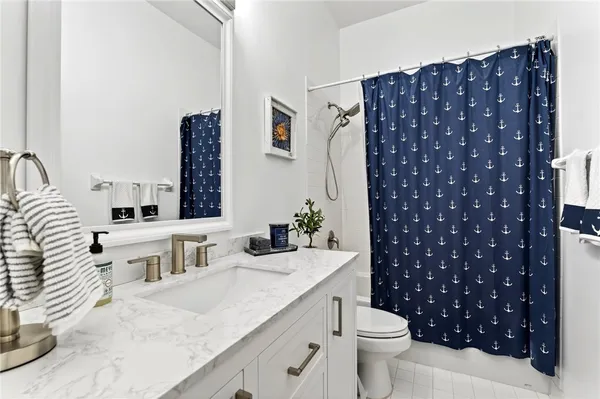 a bathroom with a sink vanity mirror and toilet