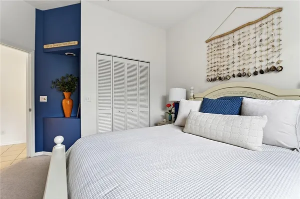 a bedroom with a bed and a painting on the wall