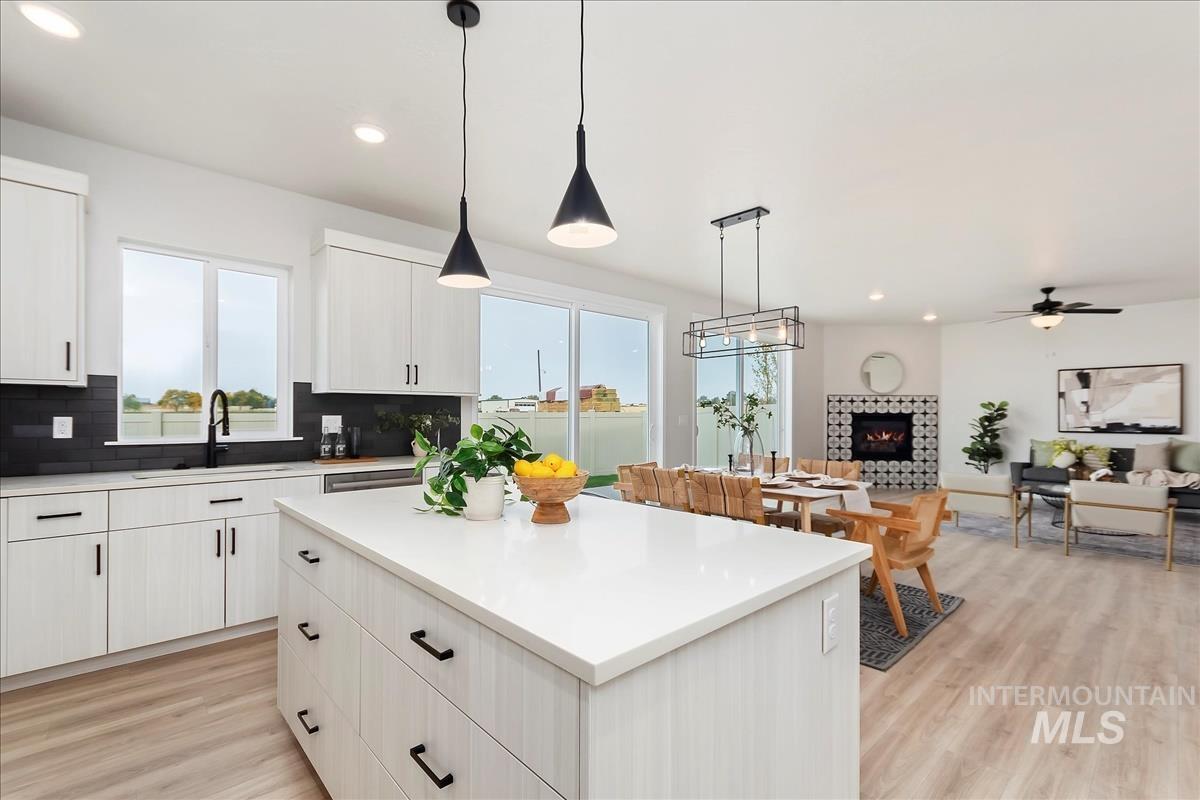 2702 West Gidran Meridian, ID 83642 - Photo 13 of 30 Kitchen featuring pendant lighting, a fireplace, recessed lighting, white cabinets, and light wood-type flooring