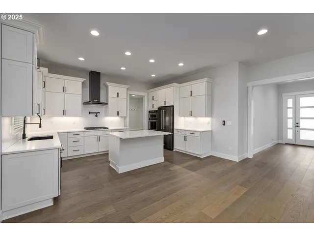 a open kitchen with kitchen island white cabinets and stainless steel appliances