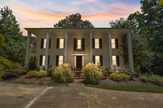 a front view of a house with plants