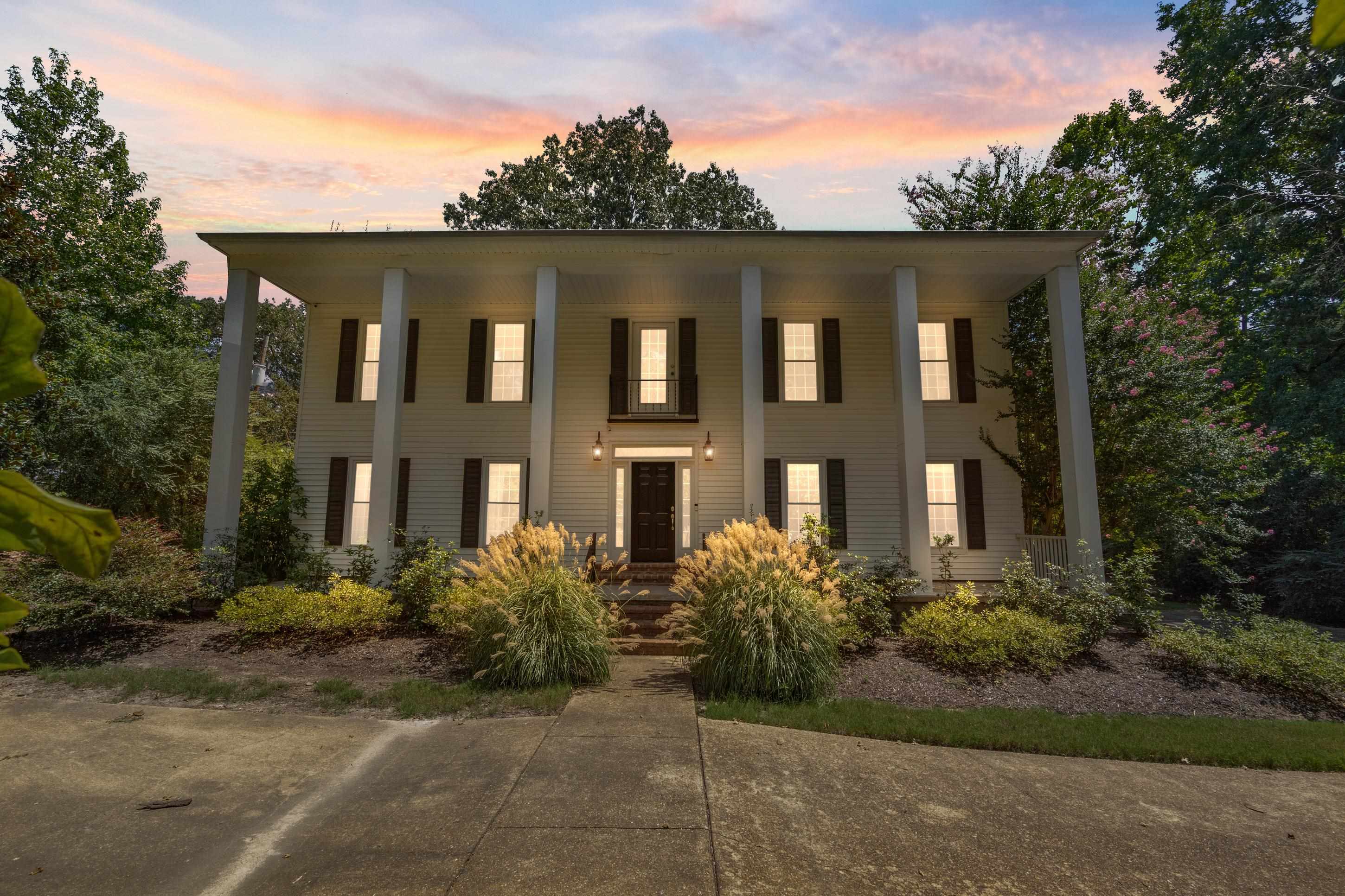 a front view of a house with plants