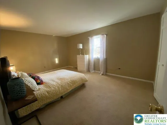 a spacious bathroom with a granite countertop double vanity sink a mirror and a shower