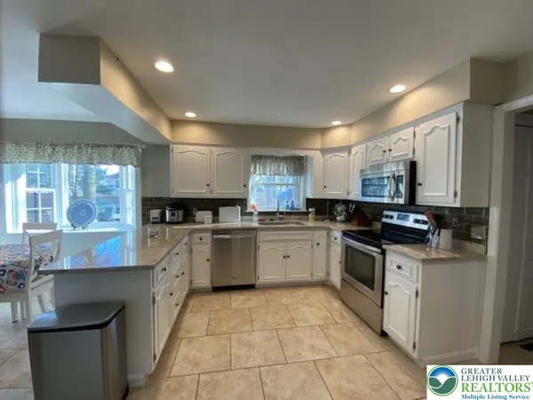 a kitchen with stainless steel appliances granite countertop a sink and a stove