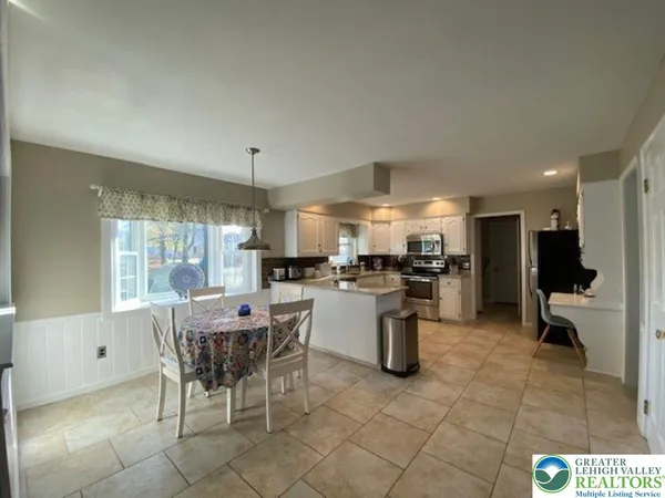 a kitchen with a sink and chairs