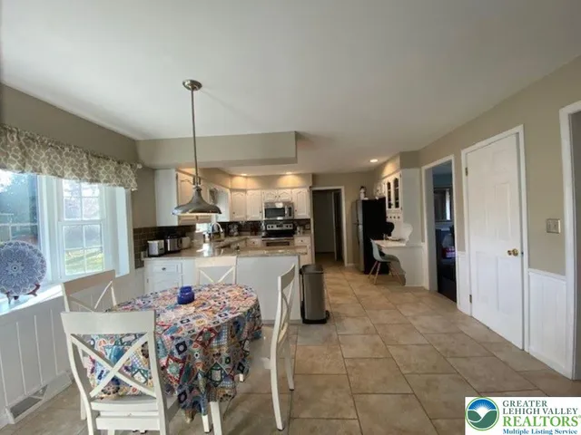 a open kitchen with stainless steel appliances granite countertop a refrigerator a sink a stove and a dining table with the view