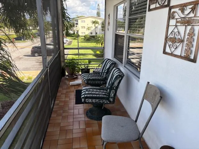a balcony with couple of chairs and a couch
