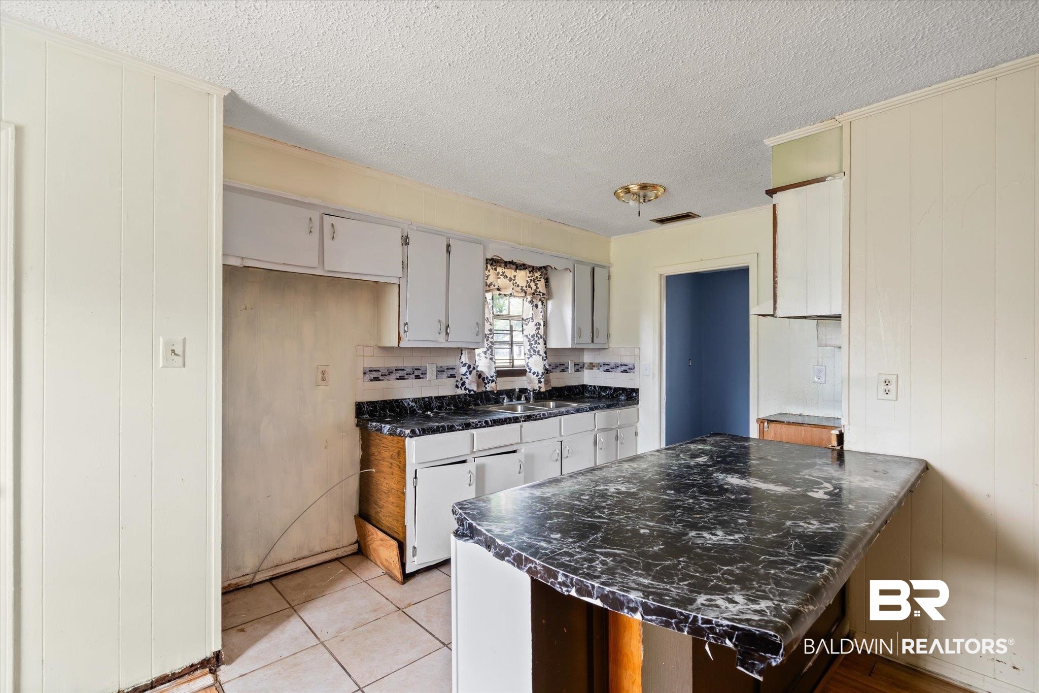 313 West 4th Avenue Foley, AL 36535 - Photo 4 of 20 Kitchen with light tile patterned flooring, tasteful backsplash, sink, kitchen peninsula, and a textured ceiling