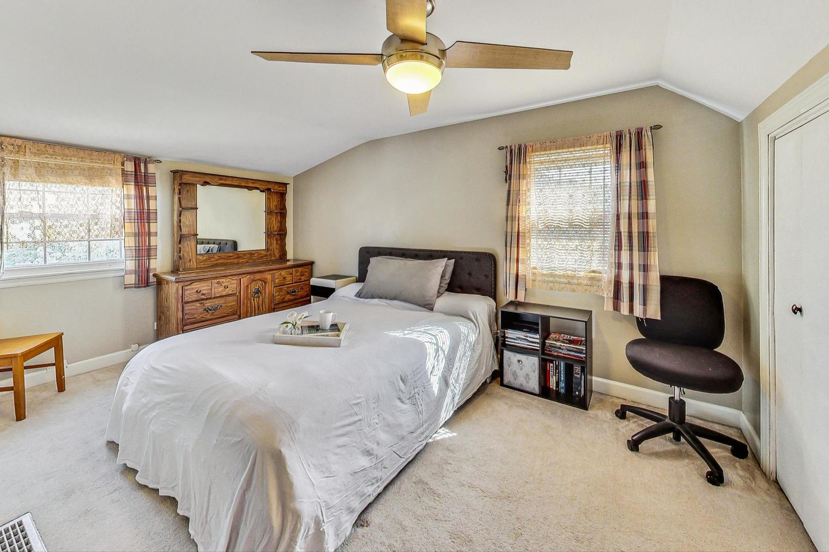 1738 Morse Avenue Des Plaines, IL 60018 - Photo 12 of 31 a bedroom with a large bed and a chandelier