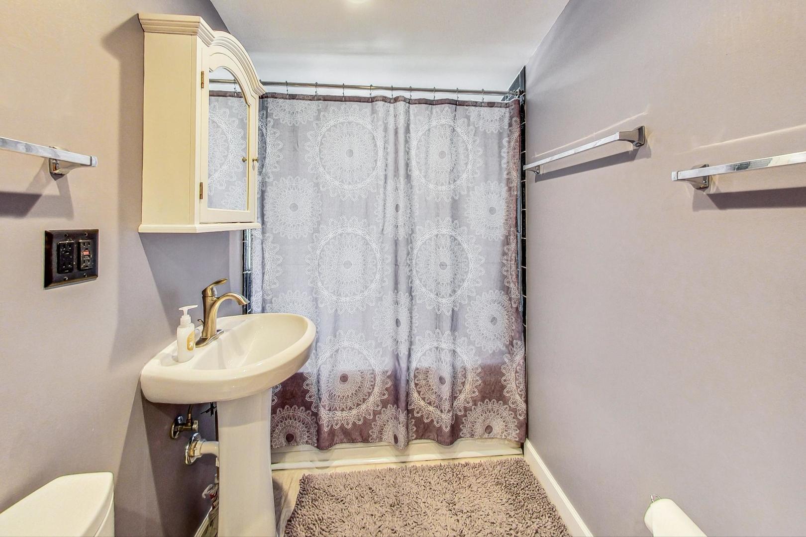 1738 Morse Avenue Des Plaines, IL 60018 - Photo 14 of 31 a bathroom with a sink a toilet and shower