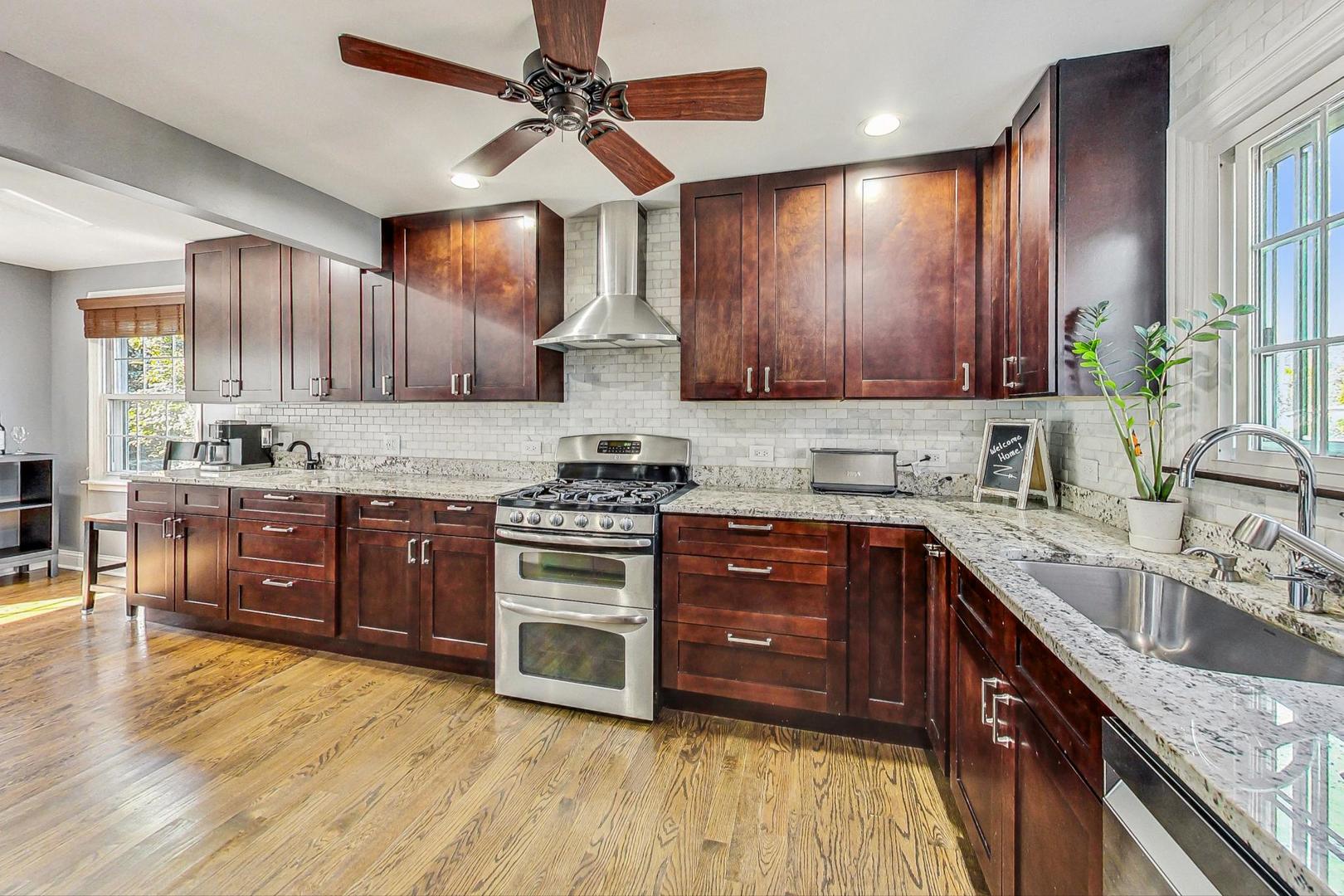 1738 Morse Avenue Des Plaines, IL 60018 - Photo 2 of 31 a kitchen with stainless steel appliances granite countertop a stove a sink dishwasher and a refrigerator with wooden cabinets