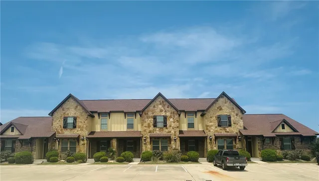 a front view of a residential apartment building with a yard