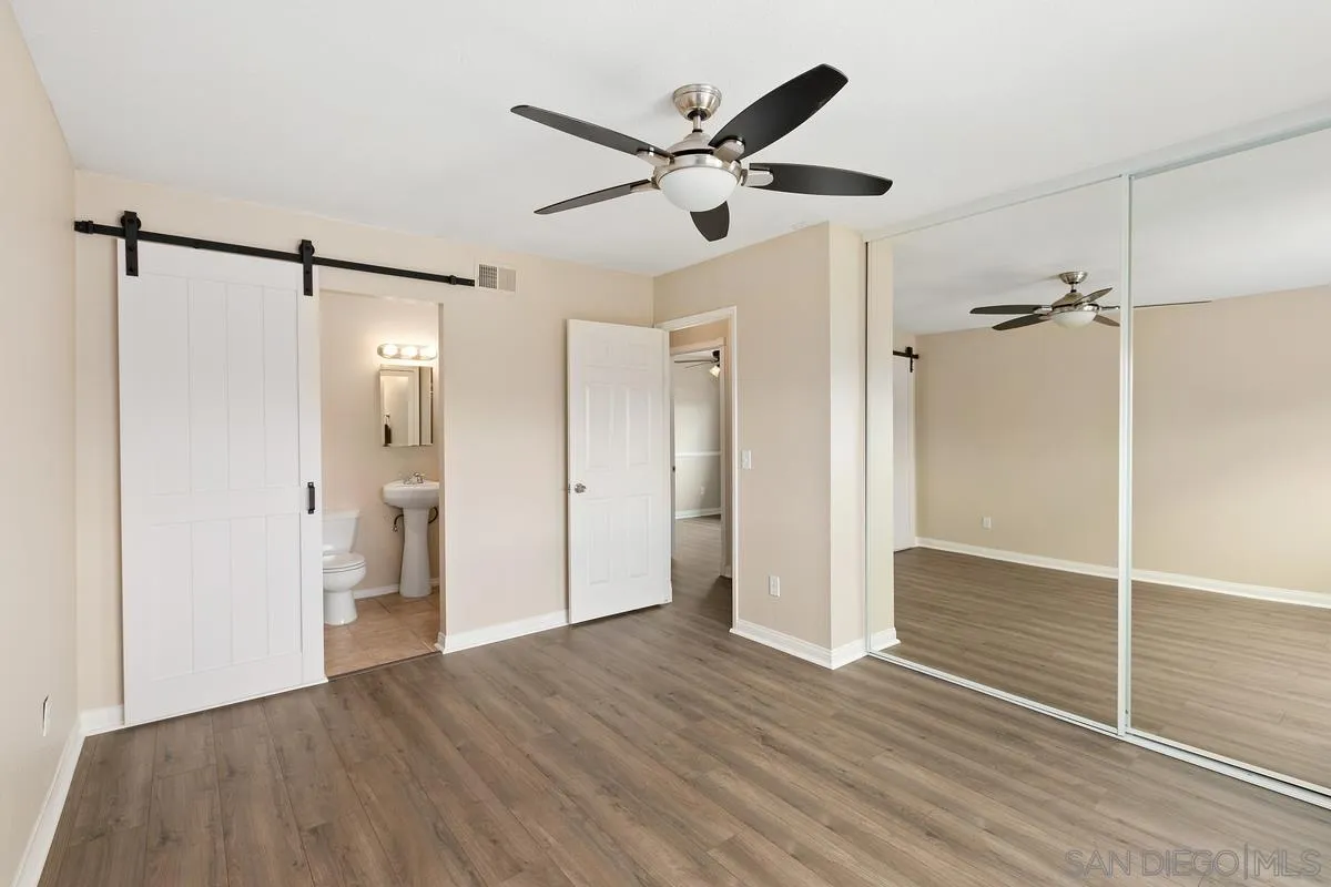 10025 Pinewood View Santee, CA 92071 - Photo 17 of 29 a view of an empty room with wooden floor and a ceiling fan